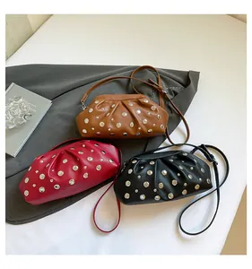 Vue de dessus de sacs à main cloutés en forme de nuage en marron, rouge et noir