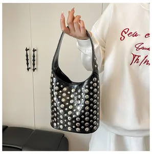 Detailansicht aus glänzendem schwarzem Lackleder mit silbernen Metallnieten an der Tasche