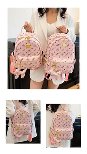 Détail du sac à dos rose avec motifs d'ours noirs et plaque logo en métal doré brillant