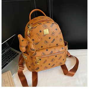 Détail du sac à dos marron texturé avec imprimé ours et rivets dorés décoratifs