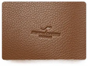 Close-up of embossed kangaroo logo on brown lychee texture leather tote bag