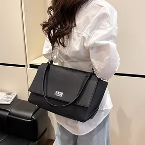 Minimalist black pebble leather tote bag with silver twist lock and side wing design