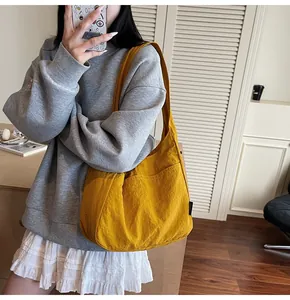 Detail of ginger yellow fabric tote bag with soft texture and stylish black side label