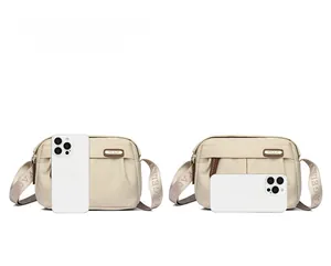 Size comparison of beige nylon crossbody bag next to an iPhone 15 Pro Max