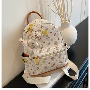 Détail d'un sac à dos crème avec imprimé ours, bordure en cuir et fermeture éclair dorée