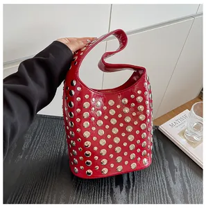 Detail der roten Hobo-Tasche mit Nieten, glänzendem Finish und silbernen Beschlägen