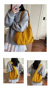 Close-up of bright yellow pleated canvas tote bag worn by a model in casual setting