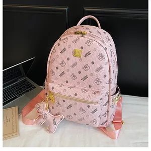 Détail d'un sac à dos en cuir rose avec imprimés d'ours et plaque logo dorée en métal