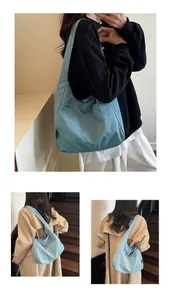 Close-up of light blue hobo bag showing side pocket and soft nylon fabric texture