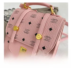 Detailed macro view of pink pebbled leather backpack with gold metal hardware and NK pattern