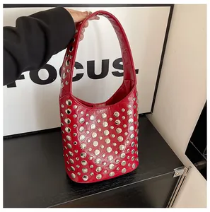 Detail der roten Lackleder-Beuteltasche mit silbernen Metallnieten und Handgriff