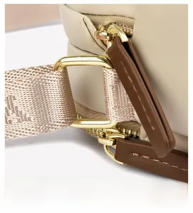 Detail of high-density oxford fabric with gold metal zippers and brown leather trim