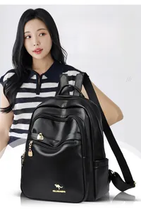 Detail of black pebbled leather backpack showing the gold logo and metal zipper textures