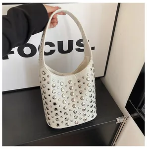 Detail der weißen Hobo-Tasche mit silbernen Nieten und breitem Schultergriff
