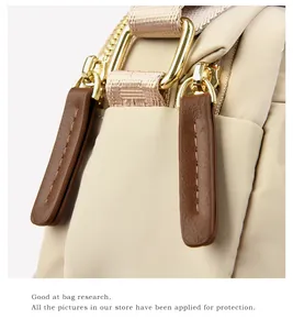 Macro shot of durable beige oxford cloth texture with premium gold D-ring and brown leather trim