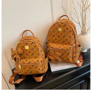 Vue détaillée des sacs à dos à monogramme avec motifs d'ours et ferrures dorées
