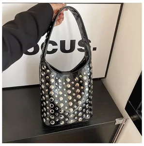 Detailaufnahme der schwarzen Lackledertasche mit dichten silbernen runden Nietendetails