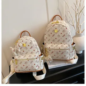 Vue détaillée des sacs à dos en similicuir beige avec motif ours et fermetures dorées