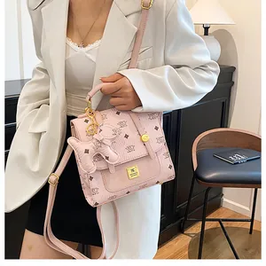 Detail of pink monogram backpack with textured leather and cute bear charm accessory