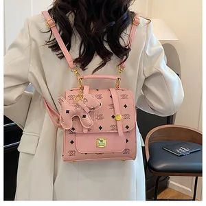 Detail of pink monogram backpack featuring golden hardware and a cute dog charm accessory