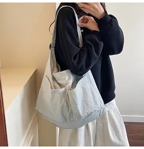Detail view of large grey tote bag featuring unique pleated texture and functional pockets