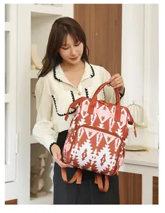 Detalle de la bolsa de pañales con estampado geométrico rojo y bolsillo frontal grande