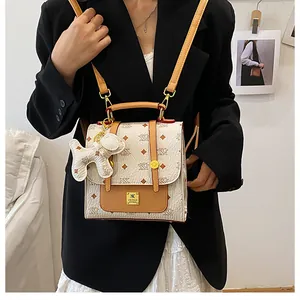 Detailed view of the vintage monogram backpack featuring a gold logo and a cute dog charm