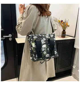 Große Reisetasche mit Totenkopf-Blumenprint, getragen zu einem beigen Trenchcoat