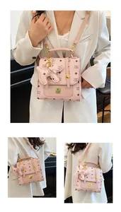 Detailed view of the monogram printed backpack with gold hardware and dog charm