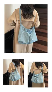 Detailed view of light blue tote bag with front pockets and wide shoulder strap