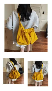 Detailed back view of a large yellow canvas crossbody bag featuring multiple exterior pockets