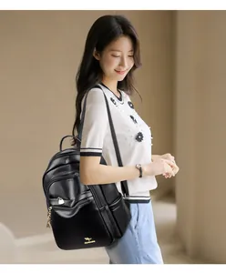 Detail of black leather backpack with gold kangaroo logo and metallic zipper pocket