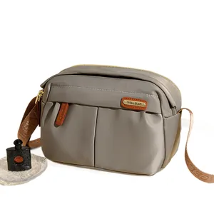 Grey Oxford cloth crossbody bag with multiple zip pockets and adjustable strap