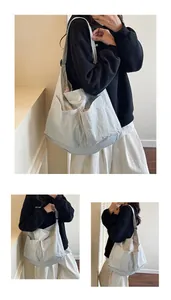 Detail view of large light grey crossbody bag with multiple front pockets and pleated texture