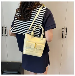 Close-up of yellow crocodile texture crossbody bag showing front pockets and strap