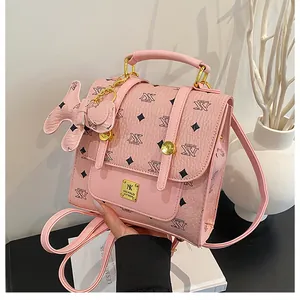 Close-up of pink mini backpack featuring logo pattern and cute puppy leather charm