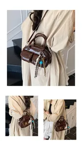 Detail view of dark brown retro shoulder bag with glossy oil wax leather and dual front pockets