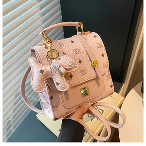 Close-up of pink textured leather backpack with floral patterns and a cute dog charm