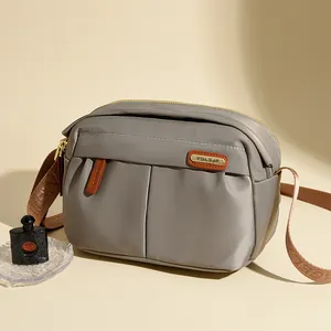 Gray Oxford cloth crossbody bag for women with brown leather label and stylish strap