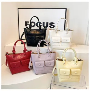 Close-up of crocodile pattern leather handbags with front buckled pockets and knot handles