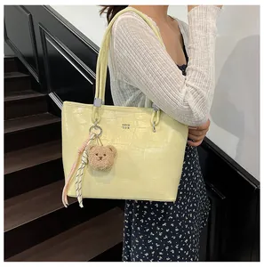 Détail du sac cabas jaune clair motif crocodile avec un charmant ours en peluche