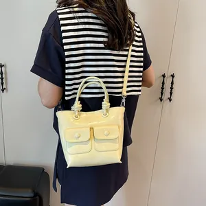Pale yellow crocodile-embossed tote bag with dual front pockets and thin shoulder strap