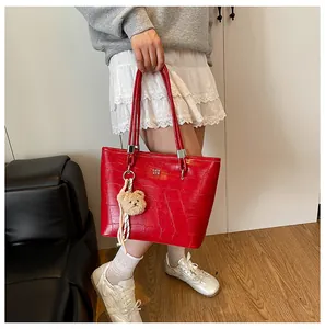 Détail du sac cabas rouge gaufré crocodile avec logo argenté et pendentif ours