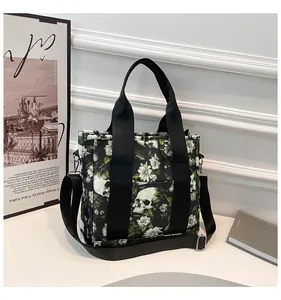 Makroaufnahme von Gothic-Totenkopf-Blumendruck auf Reisetasche mit Metallbeschlägen