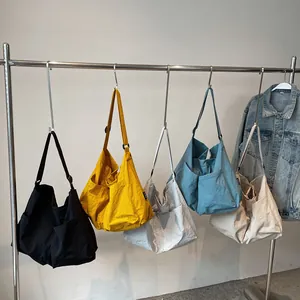 Large capacity nylon crossbody bag with side pockets in five colors on a clothing rack