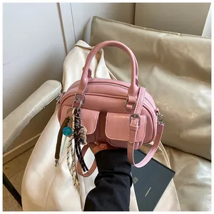 Pink glossy leather Boston bag with metal buckle pockets and cute teddy bear charm