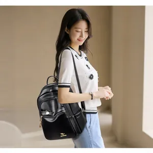 Minimalist black leather backpack with gold kangaroo logo and zipper for women