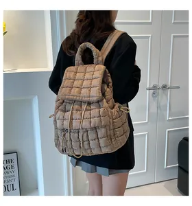 Rückansicht des Modells mit khakifarbenem gestepptem Puffer-Rucksack und Kordelzug