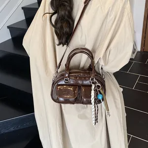 Deep brown vintage Boston bag in glossy leather with stylish charms and shoulder strap