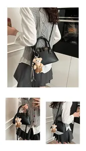 Detail view of black shell bowling bag with cute plush bear pendant and woven lanyard charm